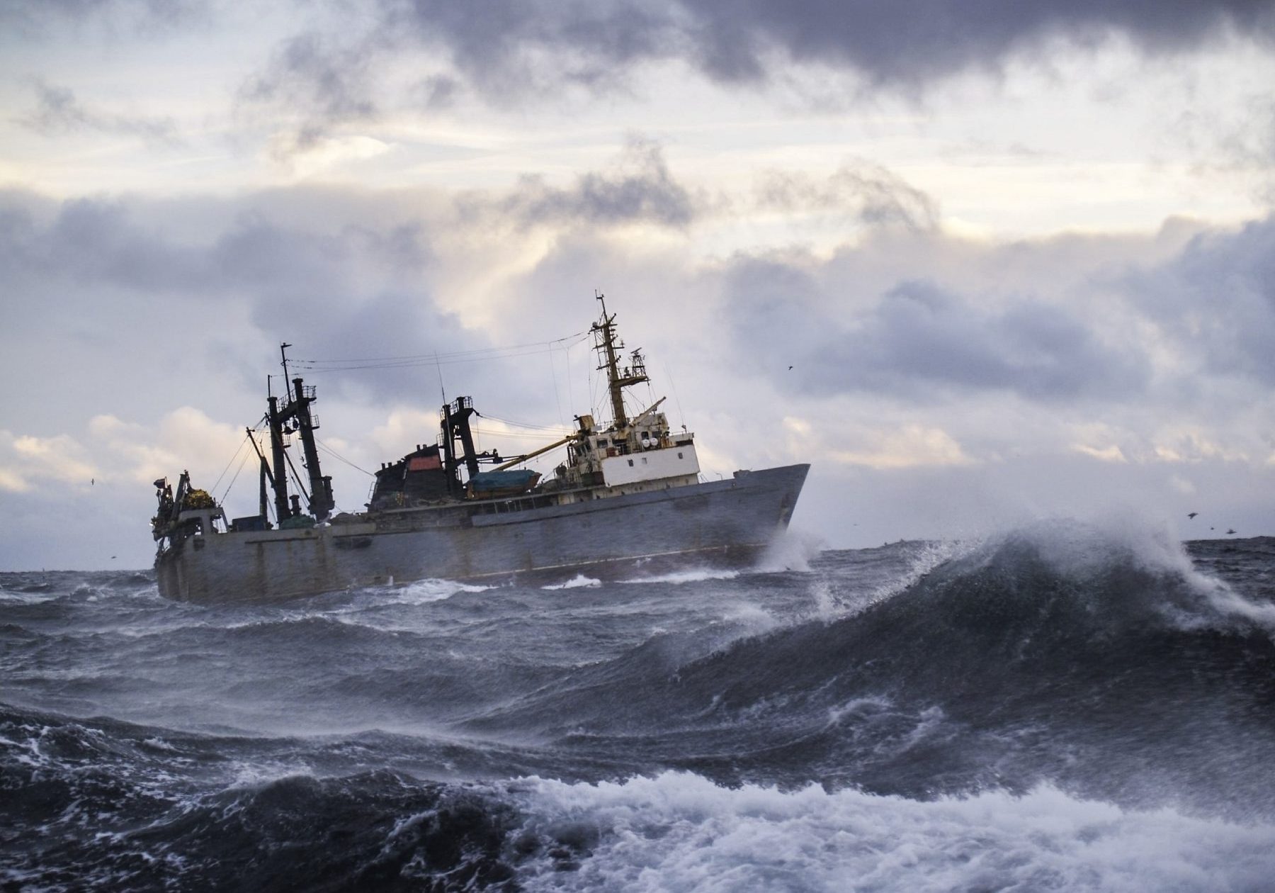 shutterstock_187015118, Fishing ship in strong storm. Sunrise.